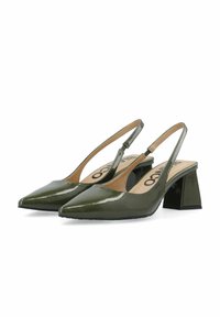 Vihreät patenttivinyylistä valmistetut slingback-kengät, joissa on terävä kärki ja paksu korko. Siinä on avoin sivuleikkaus ja brändätty pohja.