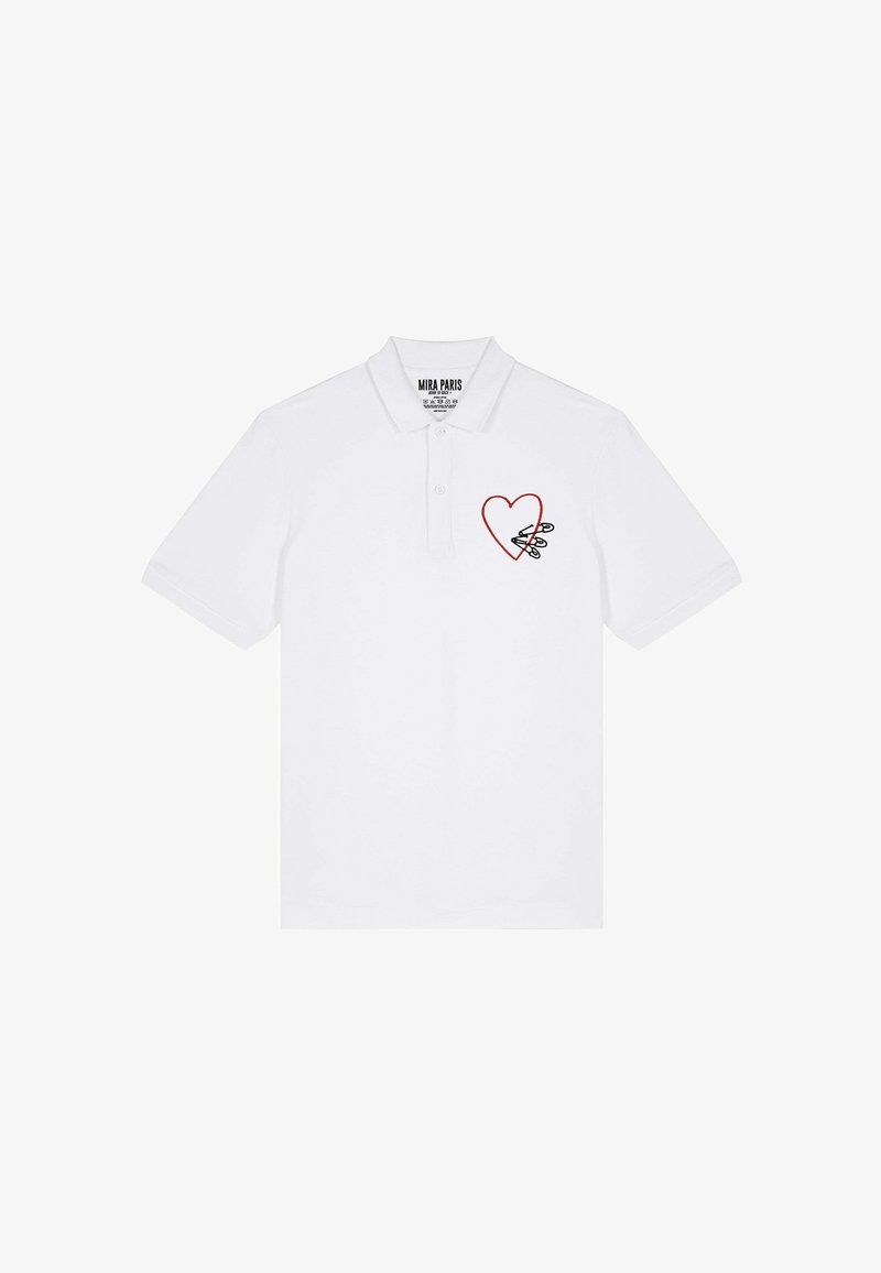 Polo blanc en coton, présentant un contour de cœur rouge avec un design d'épingles de sûreté sur la partie gauche de la poitrine. Manches courtes et col.