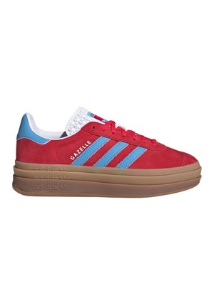 Baskets Adidas Gazelle en daim rouge avec des rayures bleues, intérieur blanc, lacets rouges et semelle épaisse marron superposée.