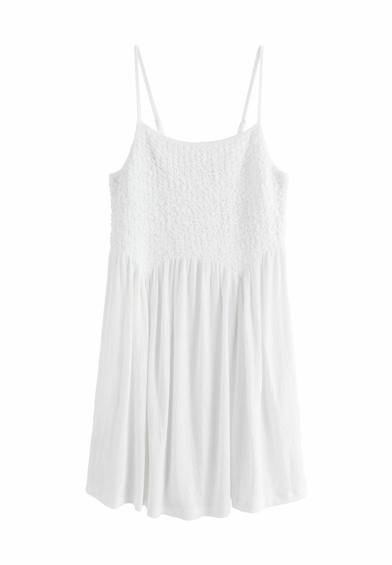 Robe blanche avec un corsage texturé, des bretelles spaghetti et une jupe fluide. Le matériau est léger et légèrement froissé.