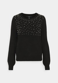 Svart långärmad tröja med rund halsringning, dekorerad med små och medelstora vita pärlor spridda över den övre framsidan och axlarna.