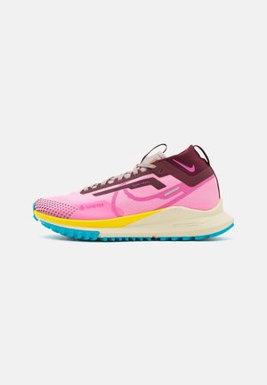 Roze en kastanjebruine Nike trail hardloopschoen met gele middenzool, blauwe buitenzool, vetersluiting en Gore-Tex materiaal voor waterbestendigheid.
