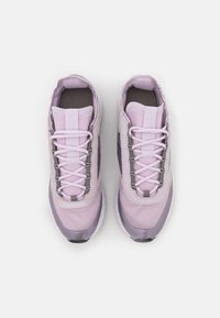 Light purple athletic shoes with a textured fabric upper, tonal overlays, and a cushioned sole. Features a lace-up front and padded collar.