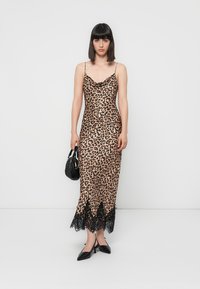 Rochie din satin cu imprimeu de leopard, cu bretele reglabile, tiv din dantelă, siluetă ajustată, asociată cu o geantă mică neagră și pantofi cu vârf ascuțit.