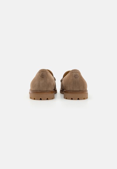 Pantofi din suede bej cu toc mic, spate rotunjit și talpă din cauciuc. Au detalii de cusătură și un logo mic pe spate.