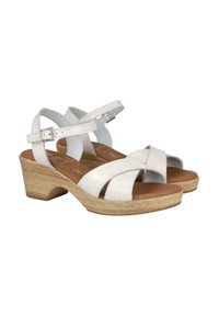 Sandalias de cuero blanco con correas cruzadas, una plantilla acolchada marrón y un tacón de plataforma de madera clara. Hebilla ajustable en el tobillo para un ajuste seguro.