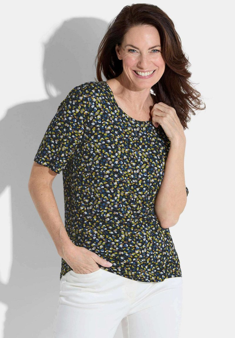 Navyblauwe top met korte mouwen en een bloemmotief in groen, wit en blauw, met een ronde halslijn en een relaxte pasvorm.