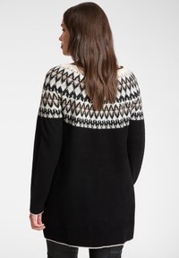 Czarny dziany sweter z wzorzystą wstawką w beżowym i brązowym kolorze. Długie rękawy, ściągacze na mankietach i prosty krój. Miękka tekstura.