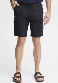 Svart cargo-shorts med snorjustering i midjen, sidelommer og en avslappet passform. Laget av lett stoff med en glatt tekstur.