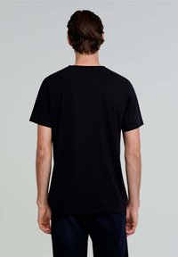 Sort bomulds t-shirt med korte ærmer og rund halsudskæring, der har en afslappet pasform og glat tekstur. Ingen synlige logoer eller mønstre.