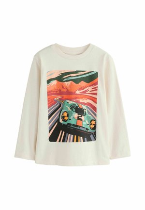 Vaaleanbeige pitkähihaine paita, jossa on värikäs grafiikka vintage-autosta kiemurtelevalla tiellä vuorten taustalla.