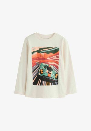 Off-white majica z dolgimi rokavi, ki prikazuje barvno grafiko starinskega avtomobila na vijugasti cesti z gorami v ozadju.