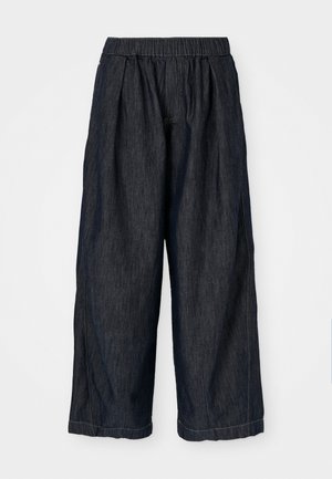 Bredde bukser lavet af mørk denim. Har en elastisk talje og sidesøm. Enkel design uden synlige mønstre eller accenter.