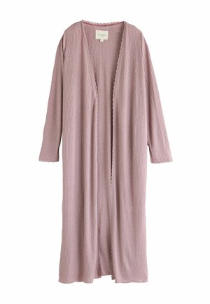 Cardigan a coste ribattezzato di un lungo rosa polveroso con bordi scallopati sulla parte anteriore aperta e sui polsini delle maniche, appeso su uno sfondo bianco.