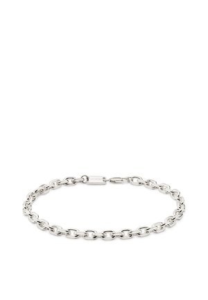 Hopeinen ketjurannerengas, jossa ovaalit lenkit ja pieni suorakaiteen muotoinen lukko, johon on kaiverrettu tuotemerkin nimi, valkoisella taustalla.