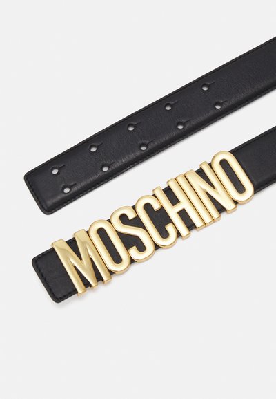 Must mustrist vöö, mille keskel on suur kuldne "MOSCHINO" logo ja millel on mitmed augud, et saaks reguleerida suurust.