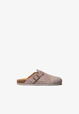 Svijetlosmeđi cipele na klizanje od brušene kože s podesivim kopčom, pluti natpeticom i bijelim teksturiranim đonom, prikazane iz bočnog profila na bijeloj pozadini.