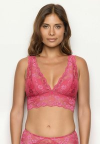 Lace bralette in het roze met een diepe V-hals, golvende randen en bloemendesigns. Zachte stof met brede bandjes voor comfort en ondersteuning.