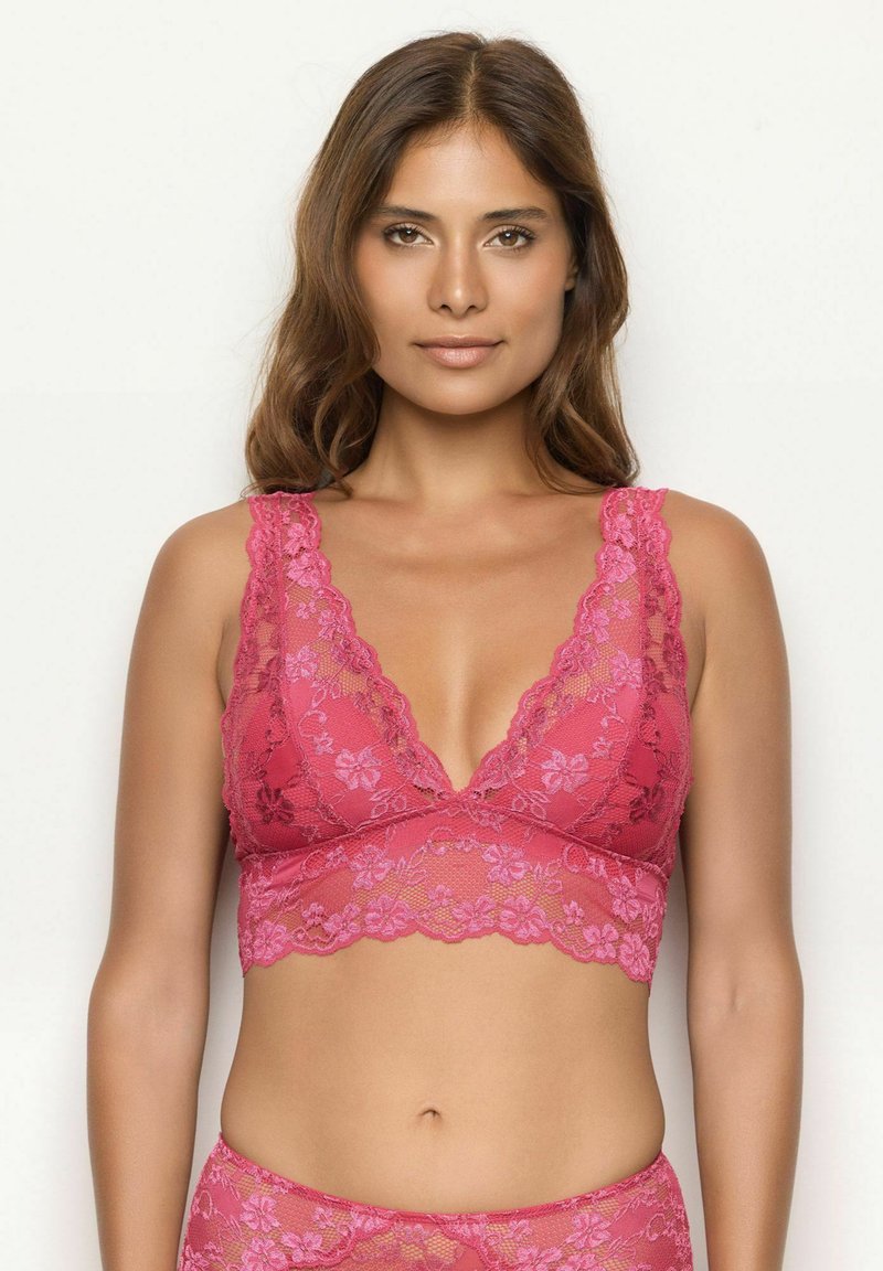 Lace bralette in het roze met een diepe V-hals, golvende randen en bloemendesigns. Zachte stof met brede bandjes voor comfort en ondersteuning.