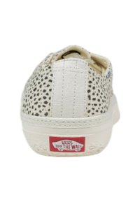 Sneaker bianca con stampa a macchie nere, materiale in tela, suola in gomma piatta e logo rosso "VANS OFF THE WALL" sul tallone.