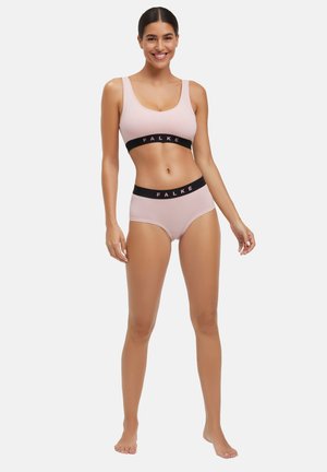 Light pink sports bra and matching high-waisted briefs with black elastic bands featuring "FALKE" logo. Smooth fabric and fitted design.
