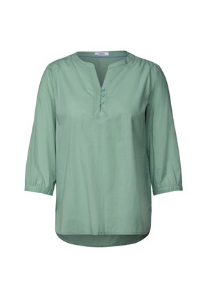 Blouse vert clair à manches trois quarts, col rond et patte de boutonnage avec trois boutons. Tissu lisse avec une coupe décontractée.