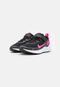 Schwarze Sportschuhe mit rosa Akzenten, ausgestattet mit einem atmungsaktiven Obermaterial aus Mesh, gepolstertem Kragen, Klettverschluss und einer weißen Zwischensohle. Strukturierte Außensohle.