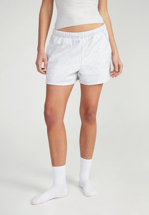 Grijze katoenen shorts met een elastische tailleband, zijzakken en een ontspannen pasvorm, gecombineerd met witte geribbelde sokken.