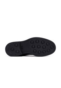 Suola nera della scarpa con borchie di gommatonde distribuite uniformemente sulla parte anteriore e sul tallone per trazione e aderenza.