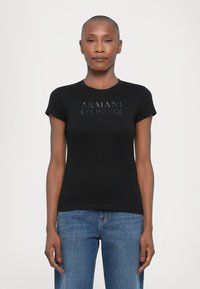 Black short-sleeve t-shirt with a round neckline, featuring a glossy "ARMANI EXCHANGE" logo on the front. Soft, fitted fabric.