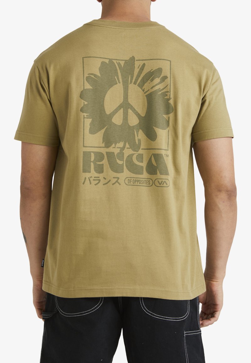 Camiseta de algodón color verde oliva con un gran estampado gráfico de un signo de paz rodeado de formas florales en la parte posterior. Diseño sencillo de cuello redondo.