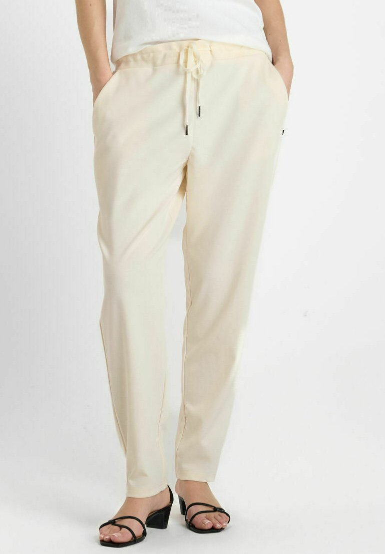 Lichtbeige pull-on broek met een elastische tailleband, een trekkoord, zijzakken en een gladde, licht glanzende stofafwerking.