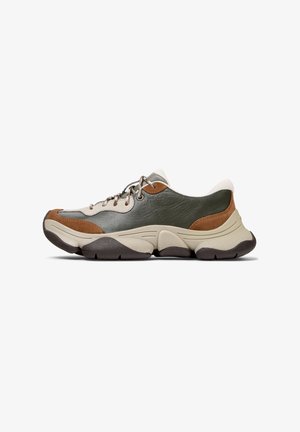 Zapatillas que combinan cuero verde, tejido beige y detalles en ante marrón, con una suela gruesa y texturizada y cordones metálicos.
