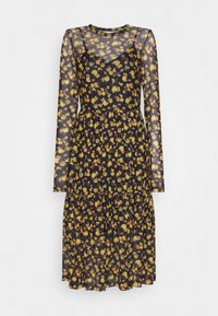 Robe noire transparente à manches longues, ornée d'un motif floral jaune. Une jupe superposée ajoute du volume et de la texture au design fluide.