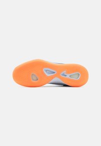 Shoe sole with an orange rubber bottom featuring a wavy texture, cutout sections, and a blue-gray accent around the edges.