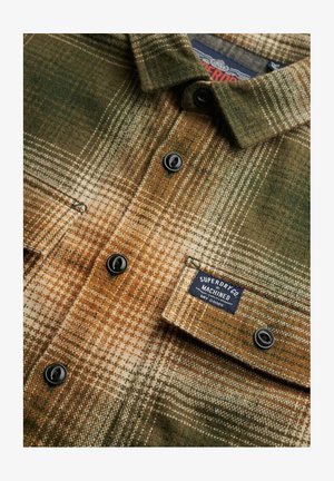 Flanellen shirt met een bruine, groene en crèmekleurige ruitprint, met zwarte knopen en een label dat "Superdry Co Machined" leest.