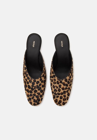 Paire de chaussures slip-on avec motif léopard et semelles intérieures noires, de marque "Neous,", sur fond blanc uni.