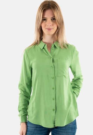 Camisa de botones de manga larga verde, fabricada con un tejido suave, que cuenta con un bolsillo en el lado izquierdo del pecho, dobladillo redondeado y puños con botones.