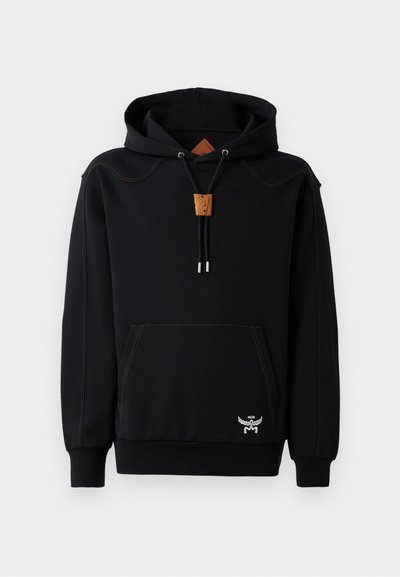 Black hoodie made of cotton blend, featuring a kangaroo pocket, orange stitching, wooden cord holder, and embroidered logo detail at hem.