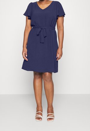 Marineblå kjole med korte flæseærmer, V-udskæring og et matchende bindebælte i taljen; lavet af et blødt, let stof.