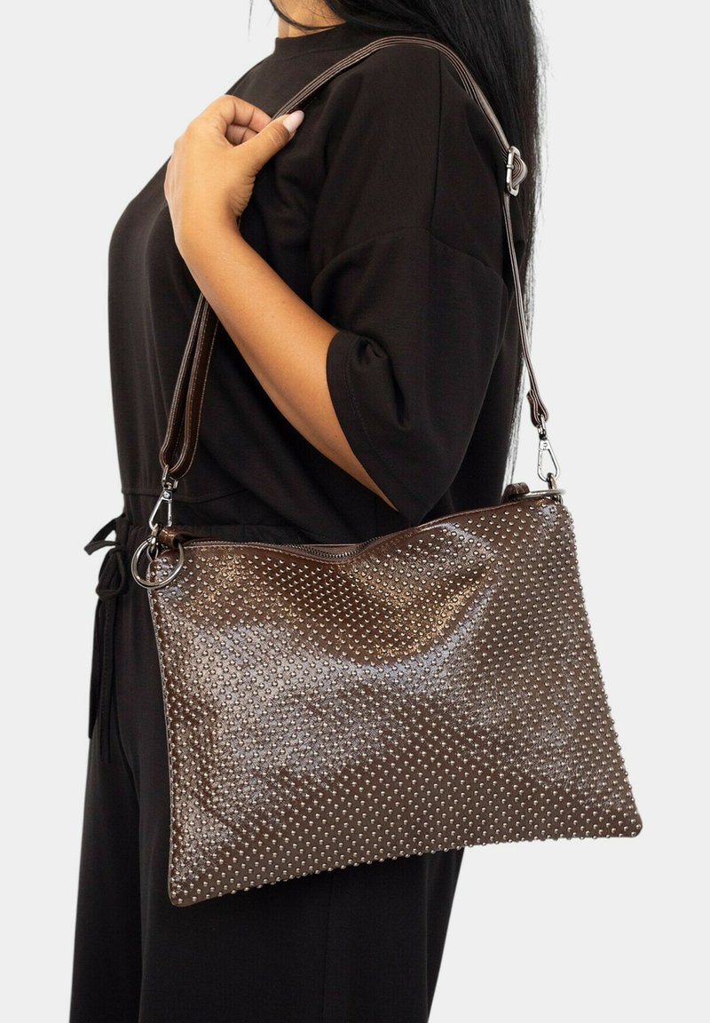 Bolso de charol marrón con textura con tachuelas, cierre de cremallera y una correa de hombro desmontable. Diseño minimalista con una silueta elegante.