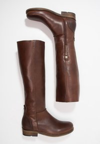 Bottes hautes jusqu'au genou en cuir marron avec une texture lisse, fermeture éclair latérale et talon bas empilé. Présentent un design simple et des lignes épurées.