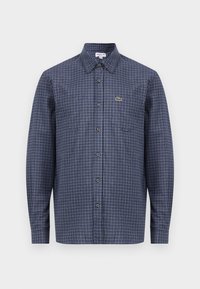 Camicia a maniche lunghe a quadri blu navy con colletto a punta e bottoni frontali. Presenta un piccolo logo verde sopra la tasca sinistra.