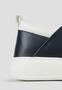 Marineblauwe leren sneakers met een gestructureerde witte rubberen zool. Beschikt over een gladde bovenkant met contrasterende panelen en een treklipje aan de achterkant.