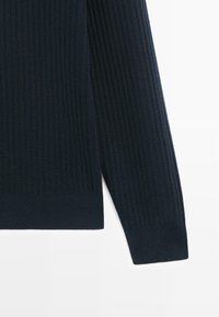 Marineblauer gerippter Pullover mit strukturierter Strickoptik, langärmlig und einfarbig. Die Bündchen sind mit einem breiteren Rippstrickband versehen.