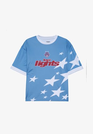 Heled sinine lühikeste varrukate ja valge kraega särk, millel on ees suur punane tekst "madalad tuled" ja valged tähtede mustrid.