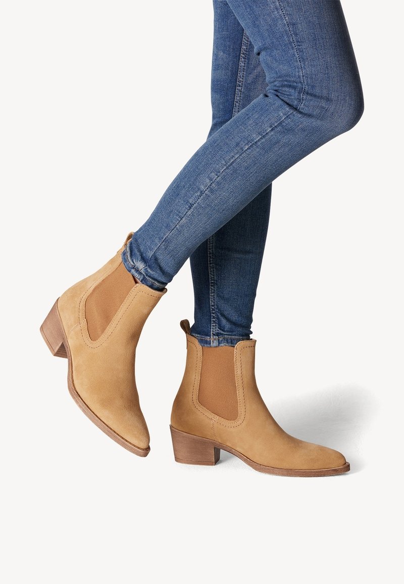 Araškové semišové Chelsea boty s elastickými bočními panely a podpatek, v kombinaci s modrými skinny jeans. Hladký povrch, zaoblený design špičky.