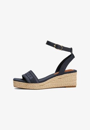 Navy blue wedge sandal with canvas upper, espadrille-style jute sole, ankle strap with adjustable buckle, and embroidered detailing on strap.
