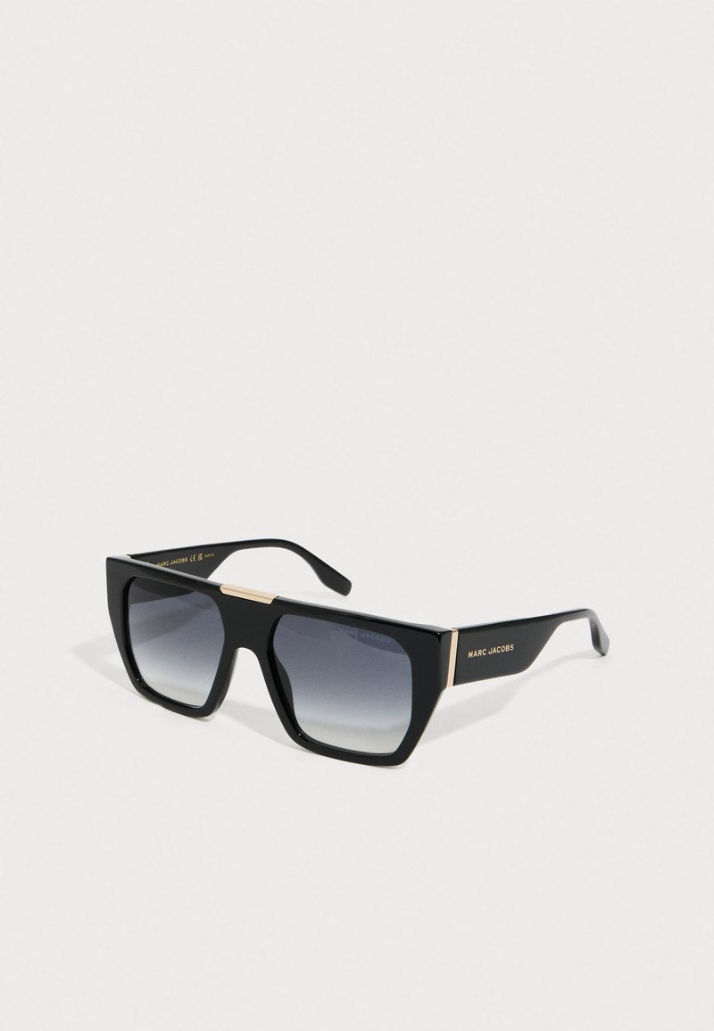 Gafas de sol cuadradas de gran tamaño en negro con lentes gris degradado y acentos dorados, con el logo de Marc Jacobs en las patillas.