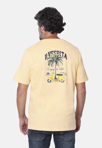 Camiseta de algodón amarilla con un gráfico de palmera y una scooter en la parte posterior, con el texto "La Vespita" y "Disfruta la Vida". Manga corta.